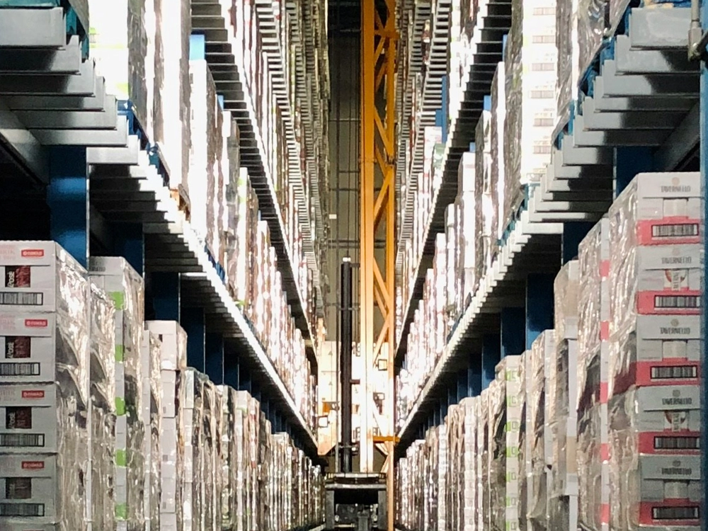 A warehouse interior filled with stacked boxes and shelves, showcasing a busy storage environment.